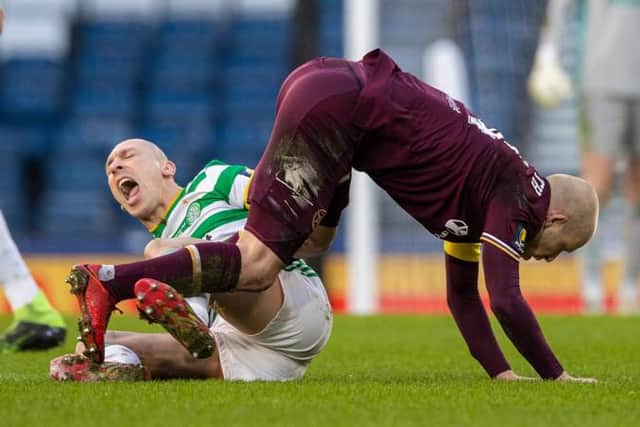 Celtic's Scott Brown writhes in pain after a challenge in midfield with Steven Naismith. (Photo by Craig Williamson / SNS Group)
