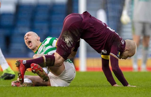 Celtic's Scott Brown writhes in pain after a challenge in midfield with Steven Naismith. (Photo by Craig Williamson / SNS Group)