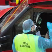 DOVER, UNITED KINGDOM - DECEMBER 24: A member of the French Federation of Rescue and First Aid swabs a lorry driver to test for Covid-19 on December 24, 2020 in Dover, United Kingdom. Travel from the UK to France is gradually resuming after being suspended due to concerns about a new strain of Covid-19. The British government deployed its Track and Trace team to administer Covid-19 tests to lorry drivers waiting to cross at Dover. (Photo by Dan Kitwood/Getty Images)