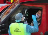 DOVER, UNITED KINGDOM - DECEMBER 24: A member of the French Federation of Rescue and First Aid swabs a lorry driver to test for Covid-19 on December 24, 2020 in Dover, United Kingdom. Travel from the UK to France is gradually resuming after being suspended due to concerns about a new strain of Covid-19. The British government deployed its Track and Trace team to administer Covid-19 tests to lorry drivers waiting to cross at Dover. (Photo by Dan Kitwood/Getty Images)