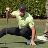 Brooks Koepka crouches as he lines up a putt on the practice green prior to the Masters at Augusta National Golf Club. Picture: Kevin C. Cox/Getty Images.