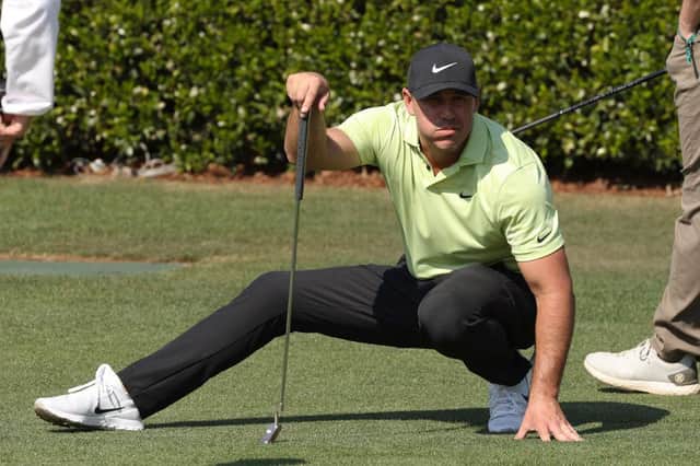 Brooks Koepka crouches as he lines up a putt on the practice green prior to the Masters at Augusta National Golf Club. Picture: Kevin C. Cox/Getty Images.