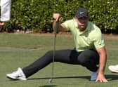 Brooks Koepka crouches as he lines up a putt on the practice green prior to the Masters at Augusta National Golf Club. Picture: Kevin C. Cox/Getty Images.