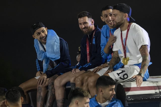 Captain Lionel Messi, send from left, sits with Angel de Maria, second from right, and Nicolas Otamendi, right, atop of a bus driving the players from the Argentine soccer team that won the World Cup after they landed at Ezeiza airport on the outskirts of Buenos Aires, Argentina, Tuesday, Dec. 20, 2022. (AP Photo/Rodrigo Abd)