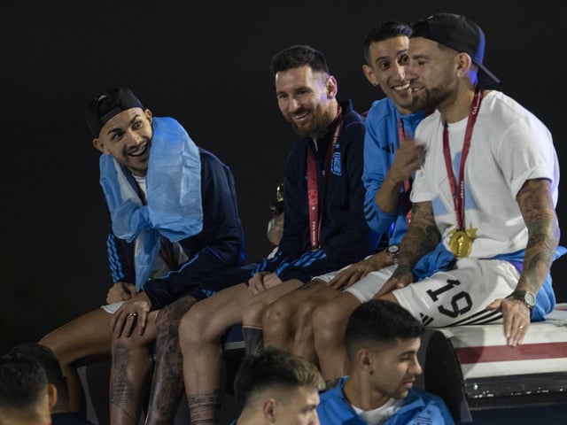 Captain Lionel Messi, send from left, sits with Angel de Maria, second from right, and Nicolas Otamendi, right, atop of a bus driving the players from the Argentine soccer team that won the World Cup after they landed at Ezeiza airport on the outskirts of Buenos Aires, Argentina, Tuesday, Dec. 20, 2022. (AP Photo/Rodrigo Abd)