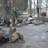 A law enforcement officer stands among the remains of an undetonated rocket next to a residential building following a missile attack in Kyiv last month.