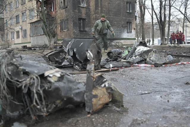 A law enforcement officer stands among the remains of an undetonated rocket next to a residential building following a missile attack in Kyiv last month.