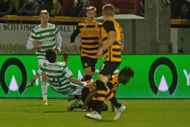 Alloa's Mouhamed Niang follows through on Celtic's Yosuke Ideguchi.