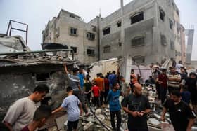 People search through buildings destroyed during Israeli air raids in the southern Gaza Strip. Heading into a third week of heavy bombing from Israel, Gaza buckles under a shortage of basic needs including fuel, whilst several neighbourhoods on the Gaza strip have been wiped out and thousands have died.
