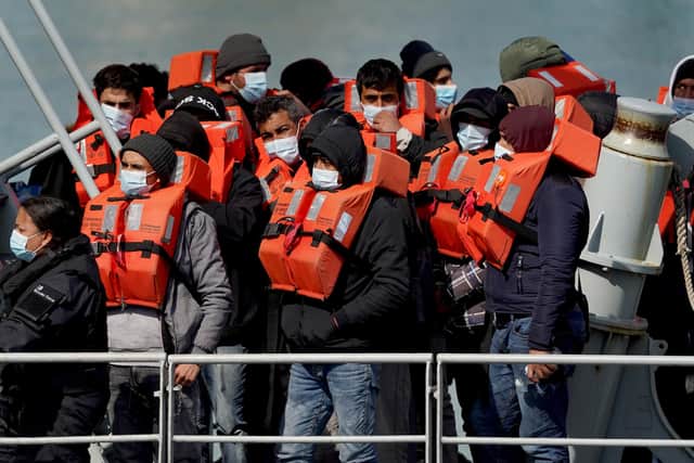 A group of people thought to be migrants are brought in to Dover, Kent, following a small boat incident in the Channel. Under a scheme designed to crack down on migrants landing on British shores after crossing the Channel in small boats, the UK intends to provide those deemed to have arrived unlawfully with a one-way ticket to Rwanda. Picture date: Friday April 15, 2022.