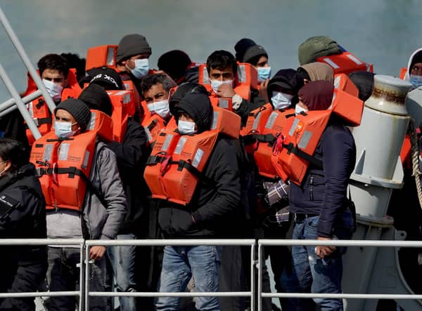 A group of people thought to be migrants are brought in to Dover, Kent, following a small boat incident in the Channel. Under a scheme designed to crack down on migrants landing on British shores after crossing the Channel in small boats, the UK intends to provide those deemed to have arrived unlawfully with a one-way ticket to Rwanda. Picture date: Friday April 15, 2022.
