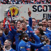 Rangers captain James Tavernier holds aloft the Scottish Cup in the midst of his jubilant team-mates after the Hampden victory over Hearts. (Photo by Ian MacNicol/Getty Images)
