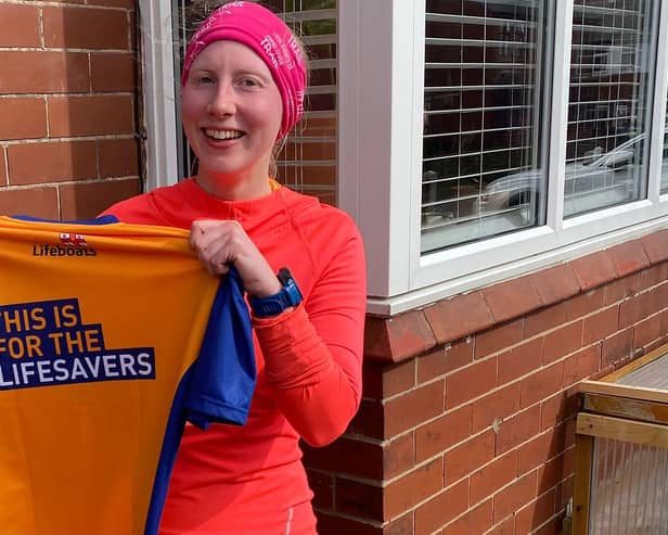 Louise Houghton holding a T-shirt made ahead of a 10k race to raise money for the RNLI. She was rescued after suffering several broken bones in an abseiling accident in Orkney. Photo: RNLI/PA Wire