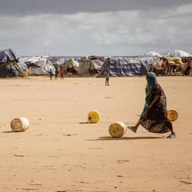 Somali children in the Dadaab refugee camp in Kenya roll water containers towards their makeshift shelter. Five consecutive seasons of failed rains have driven many Somalis to leave their country (Picture: Bobb Muriithi/AFP via Getty Images)