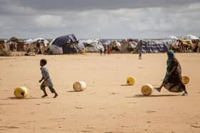 Somali children in the Dadaab refugee camp in Kenya roll water containers towards their makeshift shelter. Five consecutive seasons of failed rains have driven many Somalis to leave their country (Picture: Bobb Muriithi/AFP via Getty Images)
