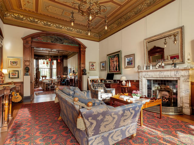 Interior: The home includes a large drawing room with sliding doors to a study/third bedroom. Its sleek kitchen boasts an electric stove, and a spiral staircase leads to a mezzanine second bedroom.