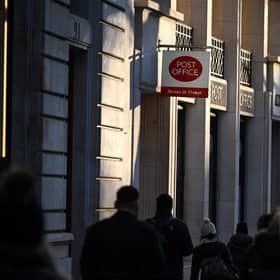 Pedestrians walk past a Post office sign. Picture: Justin Tallis/AFP via Getty Images
