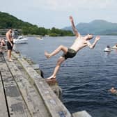 Swimmers jumping into Loch Lomond from a pier at Luss. Picture: Andrew Milligan/PA Wire