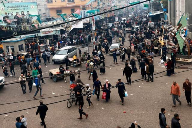 Palestinians, including many displaced from other areas in the Gaza Strip, walk through a main square in Rafah near the border with Egypt.