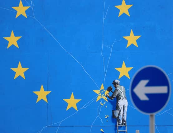 A Brexit-inspired mural by the artist Banksy shows a worker removing a star from the Flag of Europe (Picture: Gareth Fuller/PA)