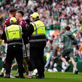 Hearts captain Lawrence Shankland is escorted from the pitch by security after Celtic fans invaded the pitch at the end of the title decider on Saturday. (Andrew Milligan/PA Wire)
