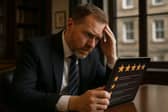 A Scottish business owner reviews online feedback, representing firms across Scotland from Edinburgh to Glasgow facing growing threats from fake reviews, with new legislation imposing fines of up to £300,000 for review manipulation.