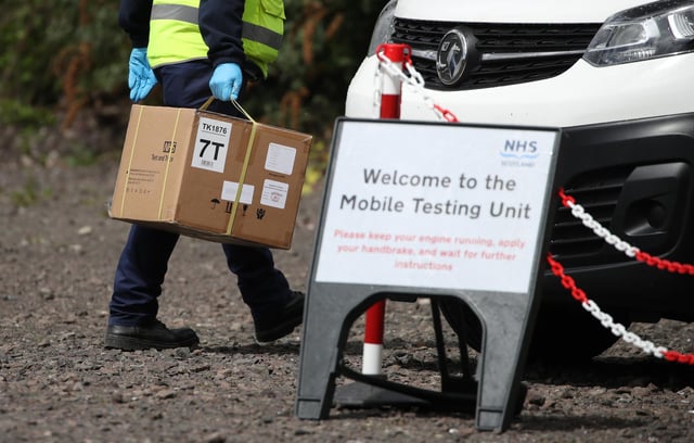 Staff from the Scottish Ambulance Service carry boxes of test kits from a van at a Covid Mobile Testing Unit. Picture: PA Media