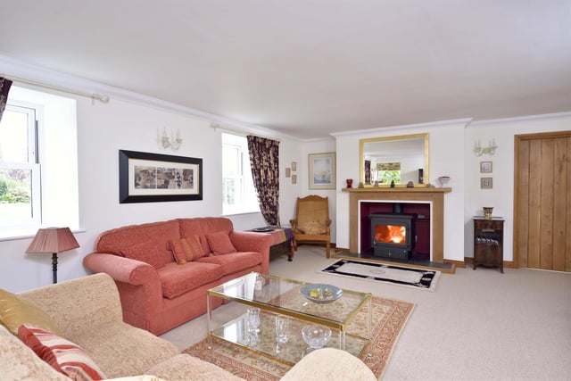 The living room boasts a bespoke fireplace with wood-burning stove