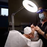 Allowing customers to remove masks for beauty treatments would help salons 'save themselves from the brink', according to the group (file image). Picture: Eric Lalmand/Belga/AFP via Getty Images.