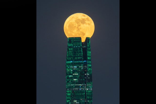 A supermoon sits at the top of the Saudi Public Investment Fund tower