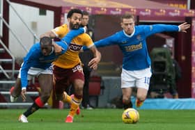 Motherwell's Jordan Roberts (centre) is challenged by Rangers' Glen Kamara and Steven Davis.