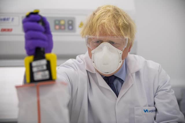 Boris Johnson tries his hand at one of the tests as he visits the French biotechnology laboratory Valneva in Livingston. Picture: Getty Images