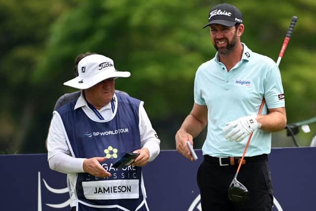 Scott Jamieson talks to his caddie Richie Blair during the second round of the Singapore Classic. Picture: Roslan Rahman/AFP via Getty Images.