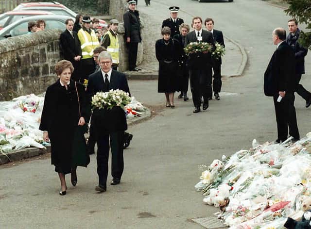 Prime Minister John Major and opposition leader Tony Blair bring their floral tributes to Dunblane Primary School after the shooting (Getty Images)