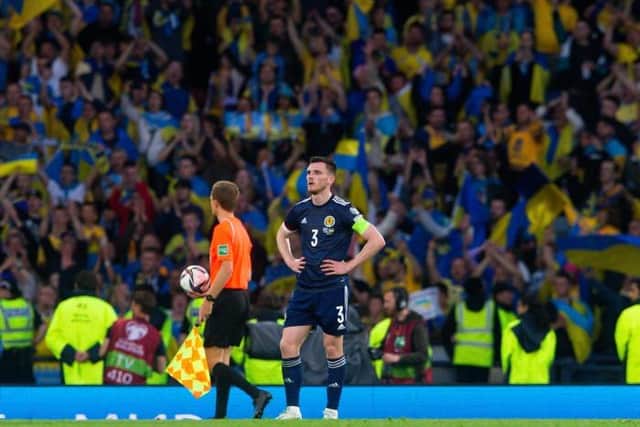 Andy Robertson at full-time as Ukraine fans celebrate at Hampden. (Photo by Ewan Bootman / SNS Group)