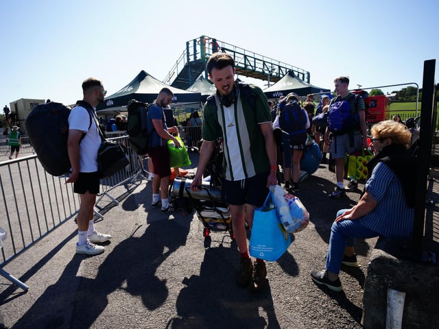 People arrive at Castle Cary train station during the Glastonbury Festival at Worthy Farm in Somerset. Stewards in high visibility jackets have been guiding hundreds of vehicles on and around the site as many of those making their way to the festival have opted to avoid train journeys.