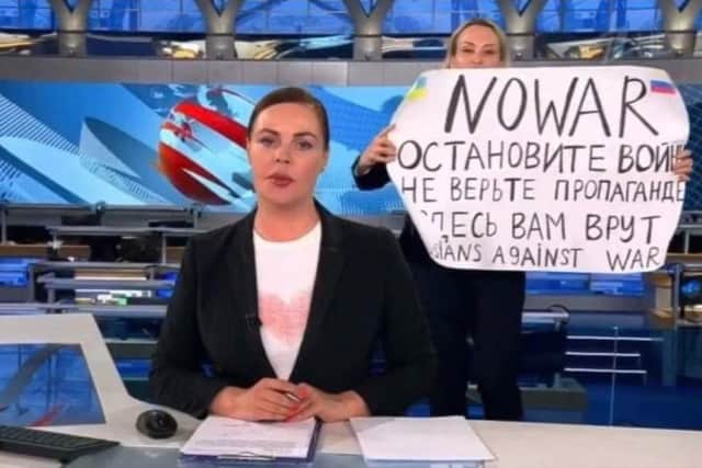 This video grab taken on March 15, 2022 shows Russian Channel One editor Marina Ovsyannikova holds a poster reading " Stop the war. Don't believe the propaganda. Here they are lying to you" during on-air TV studio by news anchor Yekaterina Andreyeva , Russia's most-watched evening news broadcast, in Moscow on March 14, 2022 .Photo: AFP PHOTO / Channel One.