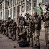Ukrainian soldiers unload their guns as they arrive at an abandoned building to rest and receive medical treatment after fighting on the front line for two months near Kramatorsk, in eastern Ukraine