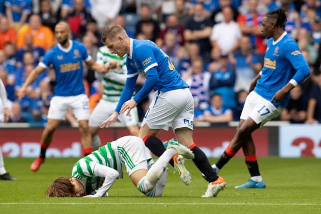 Celtic's Kyogo Furuhashi (left) goes down under the challenge of Rangers' Steven Davis during the clash at Ibrox.