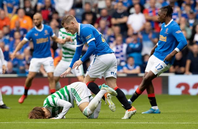 Celtic's Kyogo Furuhashi (left) goes down under the challenge of Rangers' Steven Davis during the clash at Ibrox.