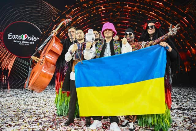 Members of the band "Kalush Orchestra" pose onstage with the winner's trophy and Ukraine's flags after winning on behalf of Ukraine the Eurovision Song contest in Turin. (Photo by Marco BERTORELLO / AFP) (Photo by MARCO BERTORELLO/AFP via Getty Images)