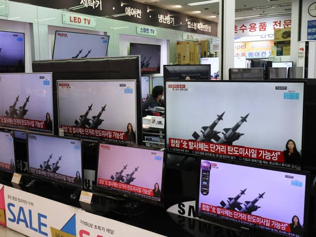 TV screens show a news program reporting about North Korea's ballistic missiles. The missiles fell into the Sea of Japan on Thursday, March 25.