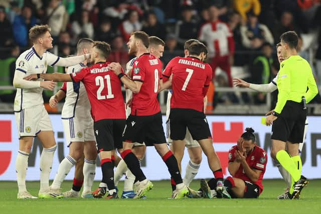 Scotland's Scott McTominay (L) argues with Georgia players during the 2-2 draw in Tiblisi. (Photo by GIORGI ARJEVANIDZE/AFP via Getty Images)