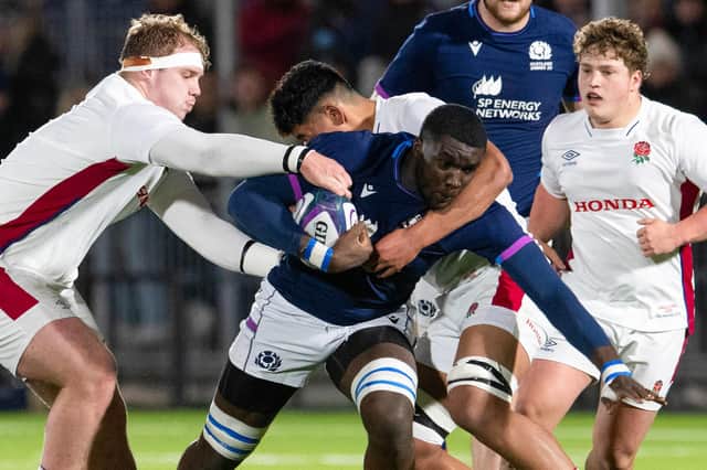 Scotland's Olujare Oguntibeju (centre) is tackled during a Six Nations Under-20 match against England.
