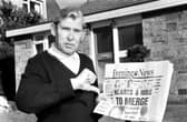 Holding a copy of the Evening News newspaper, Eddie Turnbull, former manager of Hibernian football club, gives the 'thumbs down' to Wallace Mercer's proposed Hearts & Hibs merger in 1990.