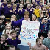 First Minister of Scotland Nicola Sturgeon alongside Evita Ye(9) who won a competition to design the First Ministers 2022 Christmas card after it was unveiled during her visit to Sunnyside Primary School in Glasgow where children at the school were involved in a competition to create the design.