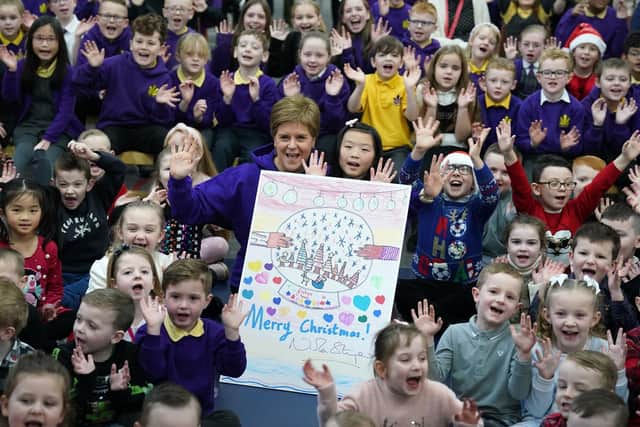 First Minister of Scotland Nicola Sturgeon alongside Evita Ye(9) who won a competition to design the First Ministers 2022 Christmas card after it was unveiled during her visit to Sunnyside Primary School in Glasgow where children at the school were involved in a competition to create the design.