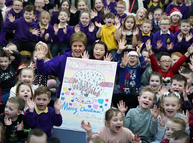 First Minister of Scotland Nicola Sturgeon alongside Evita Ye(9) who won a competition to design the First Ministers 2022 Christmas card after it was unveiled during her visit to Sunnyside Primary School in Glasgow where children at the school were involved in a competition to create the design.