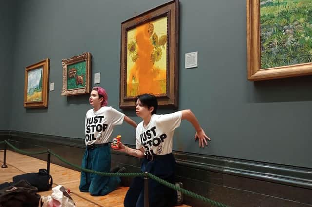 Activists cling to the wall under Vincent van Gogh's Sunflowers after tomato soup is thrown at a painting at the National Gallery in central London.  Image: Just Stop Oil / AFP