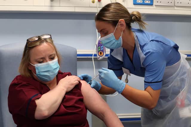 Deputy charge nurse Katie McIntosh administers the first of two Pfizer/BioNTech Covid-19 vaccine jabs to Vivien McKay Clinical Nurse Manager at the Western General Hospita, in Edinburgh.